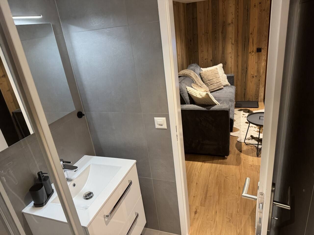 A modern bathroom with a white sink and a shower area.