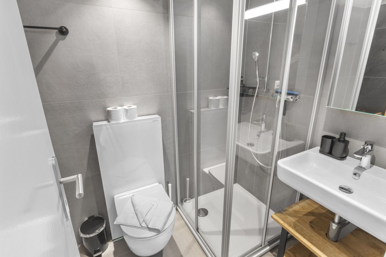 Ein modernes Badezimmer mit Toilette, Duschkabine und Waschbecken.