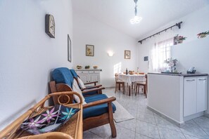 A compact living space with a dining area, kitchenette, and seating area.