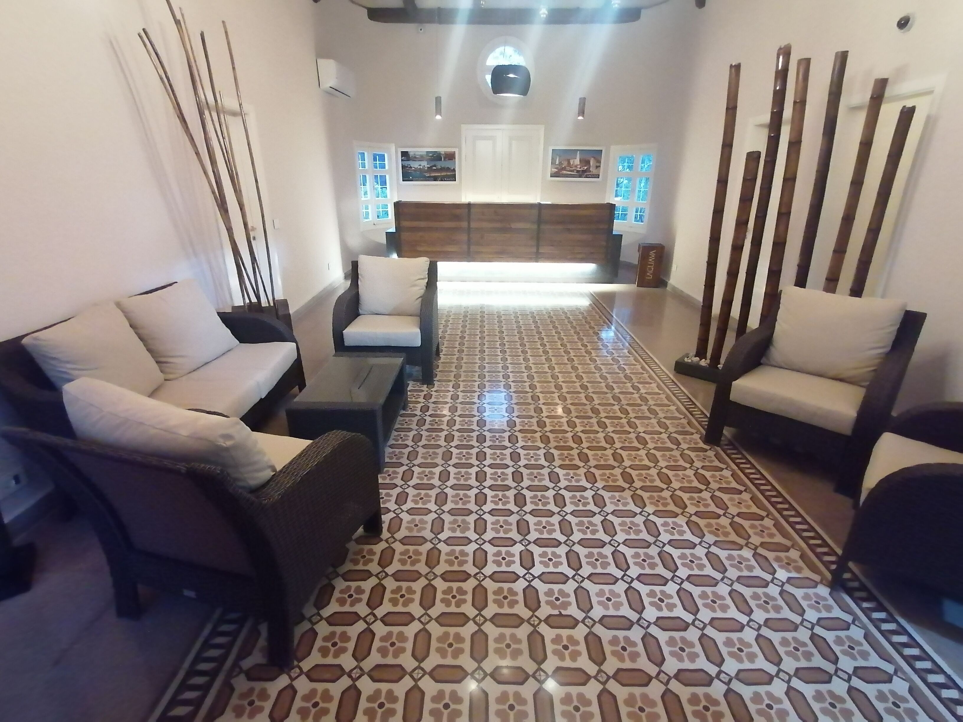 A lobby with patterned flooring, seating areas, and a reception desk.