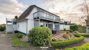 A modern two-story house with a balcony, a well-maintained garden, and a gated driveway. - Apartment 24 - 1-room apartment, TV, shower (Kappeln)