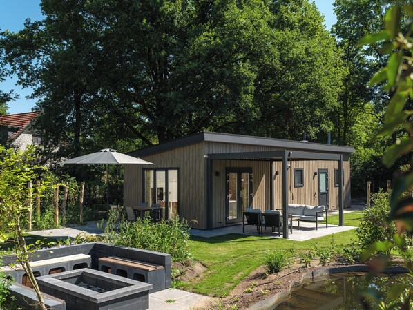 Terrace/patio - Enjoy a luxurious holiday home for 4 people in the wooded nature of the Veluwe, complete with modern amenities, air conditioning, and a stylish pergola for optimal comfort. Additionally, unwind in the private hot tub, perfect for relaxing after a day (Lieren)