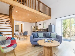 A modern apartment with a loft bedroom, a dining area, and a kitchen.