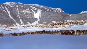 Ett snötäckt berg med en stad i dalen.