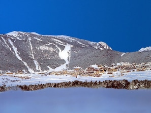 A snow-covered mountain landscape with a town in the foreground.