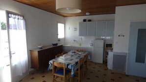 Eine kleine Küche mit Essbereich, mit Fliesenboden, Holzboden und grundlegender Ausstattung.