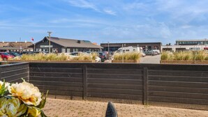 A parking area with cars and a caravan, a building with a sign 'apotek', and a clear sky. - Modern Beach House - By Traum Ferienwohnungen (Lokken)