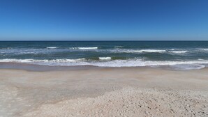A beach with a clear sky and ocean waves.