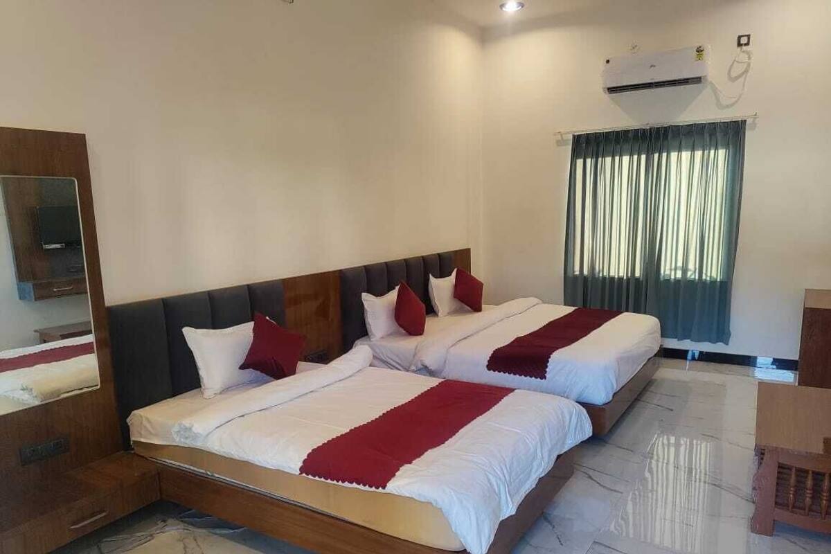 A double bed with a wooden headboard, a nightstand, and a mirror.
