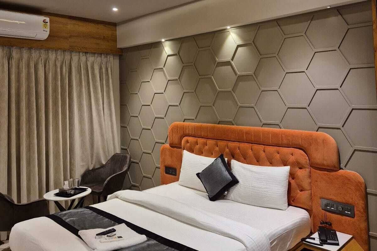Une chambre d’hôtel moderne, dotée d’un grand lit, d’un bureau et d’un ventilateur de plafond.