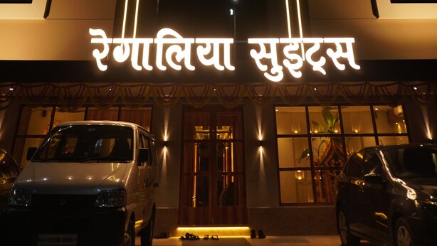 A hotel entrance with the name 'Rosalia Suites' illuminated in neon lights. - Hotel Regalia Suites (Navi Mumbai)