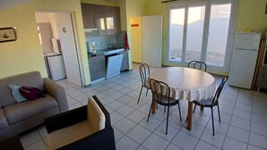 Un espacio habitable compacto con comedor, kitchenette y sofá.