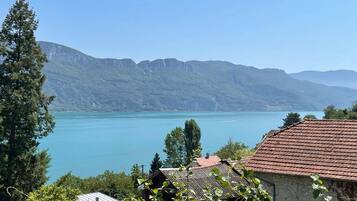 A mountainous landscape with a lake and a building with a red roof.