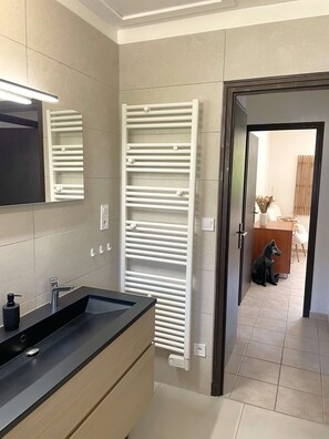 A modern bathroom with a black sink, a mirror, and a white towel rack. - Villa des Lardars · Villa 4* · Panoramic lake view & close to the beach (Conjux)