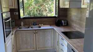 A kitchen with a window, cabinets, a sink, a stove, and a dishwasher. - Villa with panoramic lake view close to the beach (Conjux)