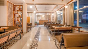 Un restaurant avec un long comptoir, des banquettes et un sol carrelé.