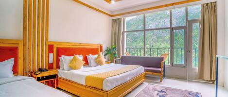 Habitación de hotel con una cama grande, una cama más pequeña, un balcón con vistas y un ventilador de techo.