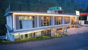 Un immeuble de deux étages doté d’un balcon, de grandes fenêtres et d’une enseigne indiquant qu’il s’agit d’un hôtel.