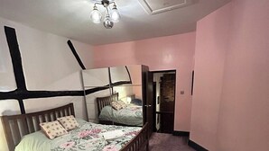Un dormitorio con cama, una silla y un escritorio.