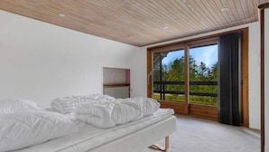 A bedroom with a bed, a radiator, and a sliding glass door to a balcony. - 5 Star Holiday Home in Lokken (Hirtshals)