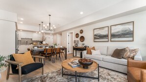 Una sala de estar moderna con sofá, mesa de centro y comedor.