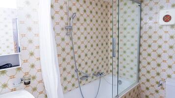 Ein Badezimmer mit einer Duschkabine, einem weißen Waschbecken und einer Toilette.