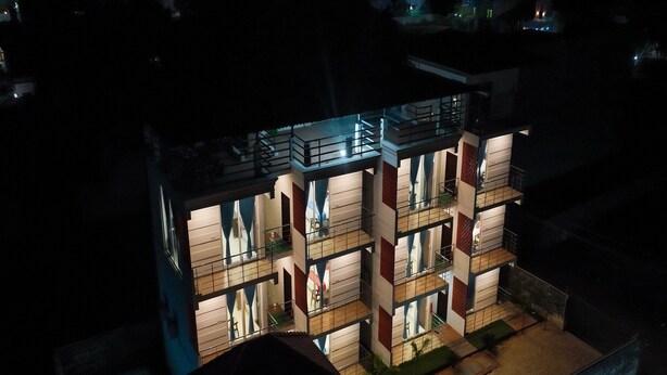 A multi-story hotel with balconies and a swimming pool. - Anglo Resort (Puducherry)