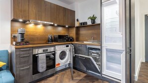 A compact kitchen with a built-in washing machine, a coffee maker, and a toaster. - 1 Bed Flat - Sleeps 4 - Pets - Parking - Wifi (Birmingham)