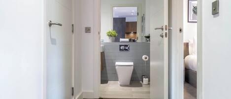 Ein modernes Badezimmer mit Toilette, Waschbecken und Duschbereich.