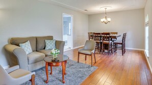 Ein Wohnzimmer mit Sofa, Sesseln, einem Couchtisch und einem Essbereich mit Tisch und Stühlen.