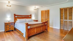 Ein Schlafzimmer mit einem hölzernen Bett, Nachttischen und einem Kleiderschrank.