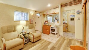 A cozy living room with a sofa, a small table with a lamp, and a fireplace. - Close to Midtown! Cozy Reno 'river Cottage' (Reno)