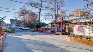 A street view with a small building with a porch, a wooden fence, and a garden bed with flowers. - Close to Midtown! Cozy Reno 'river Cottage' (Reno)