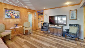 A living room with wooden flooring, a flat-screen TV, and two leather armchairs. - Half-mi to River Walk: 'rose Cottage' in Truckee! (Reno)