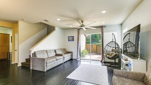 A spacious living area with a dark wood floor, a sofa, a coffee table, a ceiling fan, and a sliding glass door leading to an outdoor patio. - 20 Mi to Old Town San Diego: Stay & Play! (Chula Vista)