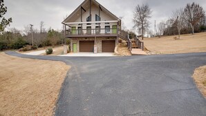 A modern two-story house with a garage, a covered porch, and a driveway leading to the entrance. - Lakefront Guntersville Apt w/ Shared Dock! (Guntersville)