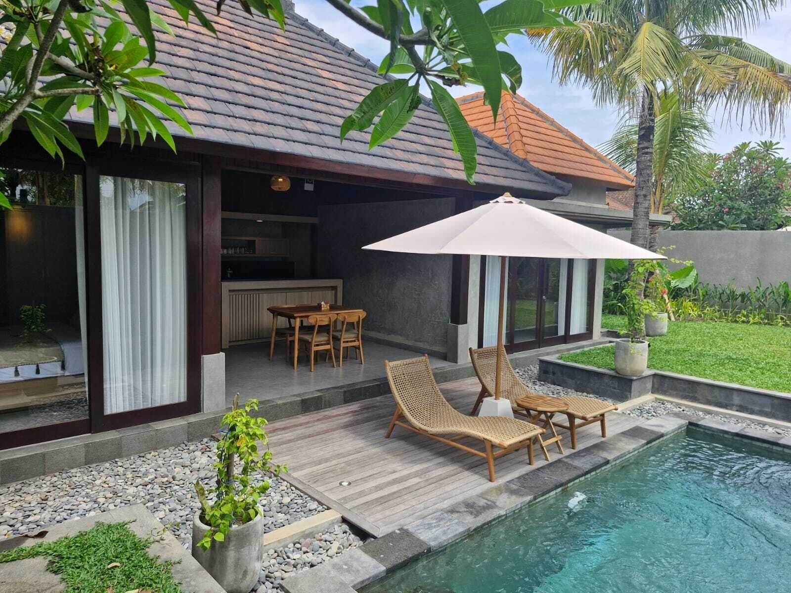 A modern house with a pool, outdoor furniture, and a dining area.