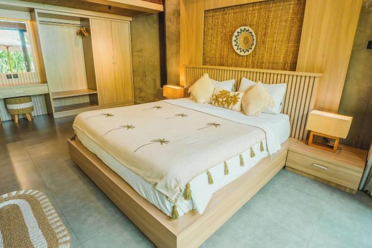 Een slaapkamer met een bed, nachtkastjes, een kledingkast en een decoratief object aan de muur.