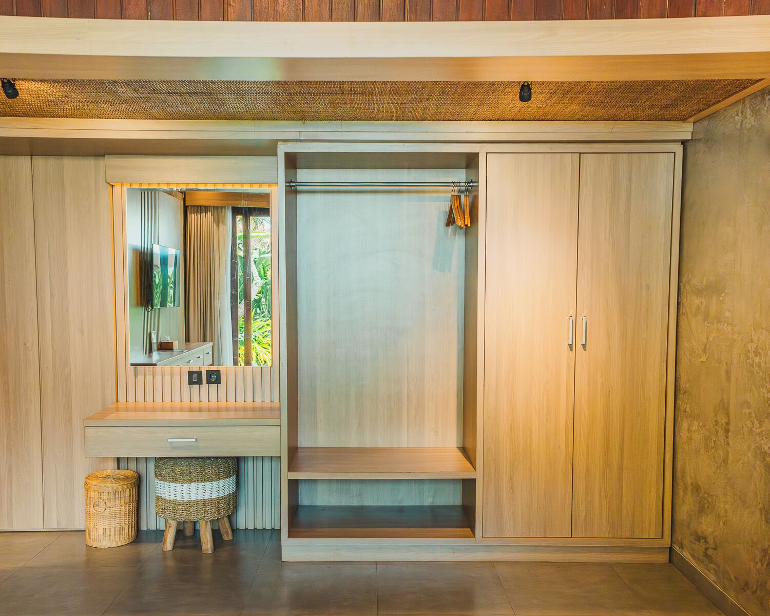 Een moderne kamer met een houten garderobe, een spiegel, een klein krukje en een plank.