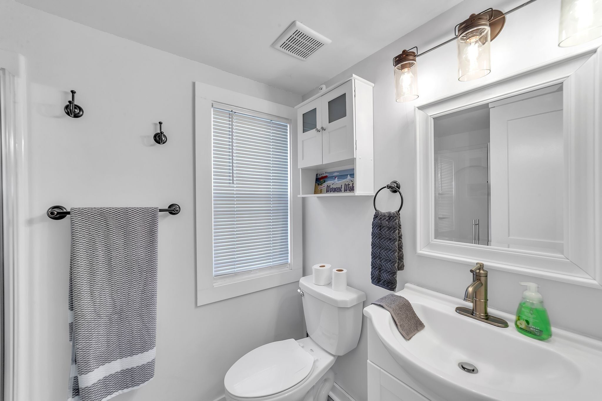 Un baño moderno con inodoro, lavabo y perchero para toallas.