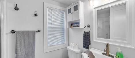 Un baño moderno con inodoro, lavabo y perchero para toallas.