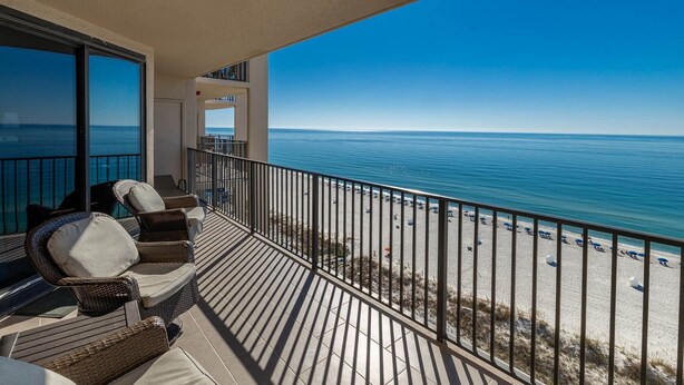 Ein Balkon mit Korbmöbeln und Blick auf den Strand.