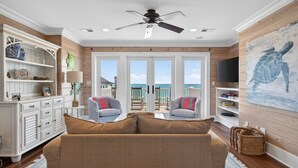 A living room with a sofa, two armchairs, a TV, and a painting of a turtle. - Sun And Solitude 7 Bedroom Home (Georgetown)