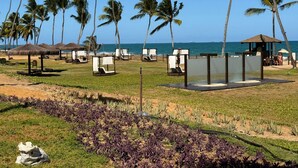 A beachside resort with thatched umbrellas, lounge chairs, and a view of the ocean. - Porto de Galinhas, Malawi Beach Resort - Flat SKY (Ipojuca)