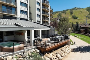 A hotel with a pool, outdoor seating, and a view of a hilly landscape. - BT201 | Amazing Views | Ski In | Ski Lockers | Indoor Pool (Steamboat Springs)