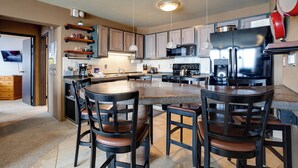 A modern kitchen with a central island, bar stools, and stainless steel appliances. - BT201 | Amazing Views | Ski In | Ski Lockers | Indoor Pool (Steamboat Springs)