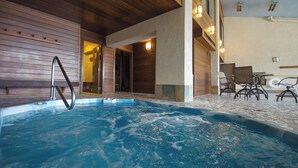 An indoor swimming pool with a wooden deck and a seating area with chairs. - BT201 | Amazing Views | Ski In | Ski Lockers | Indoor Pool (Steamboat Springs)