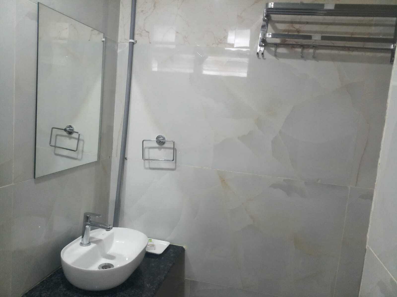 A bathroom with a white sink, a mirror, and a towel rack.