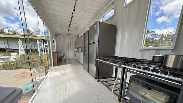 A modern kitchen with stainless steel appliances, a large window, and a view of the outdoors. - Villela House at Villela Home Stay (Lago Sul)