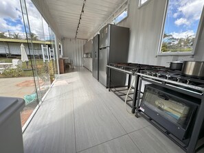 Una cocina moderna con electrodomésticos de acero inoxidable, un ventanal y vistas al exterior.